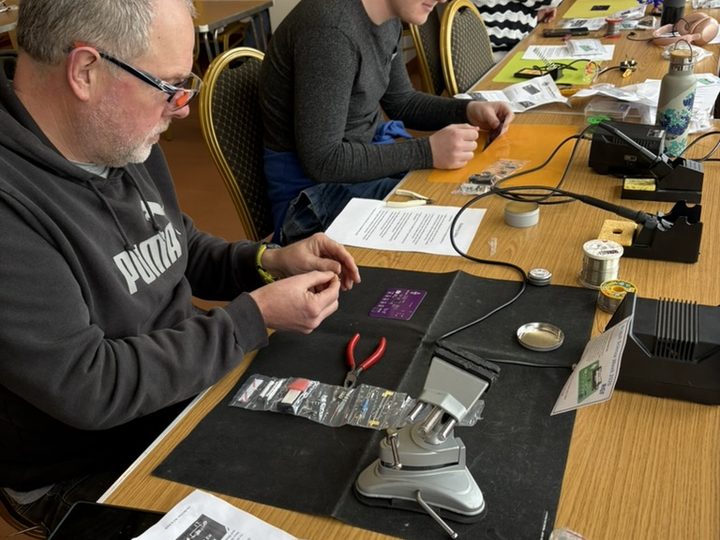 Club members assembling electronic components.